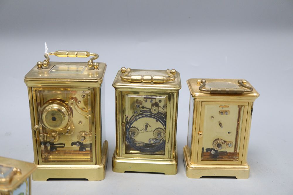 An Asprey brass cased carriage clock, another carriage clocks, two Halcyon Days carriage timepieces and an alarm clock, tallest 14cm (h